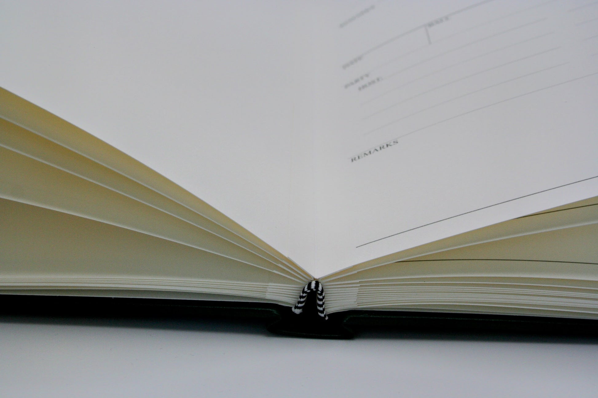 Open Ballroom Diary with lined pages on a white background and black and white contrast sewn stitching 